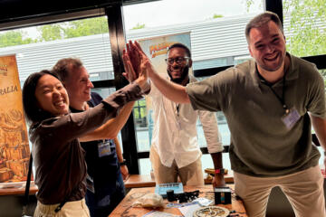 Team building participants solving puzzles during Passport to Adventure indoor team building activity.