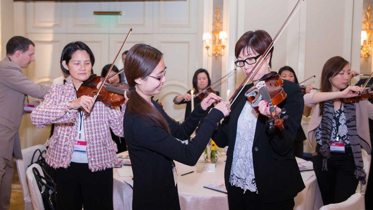 team bonding while learning to play in an orchestra with crescendo challenge team