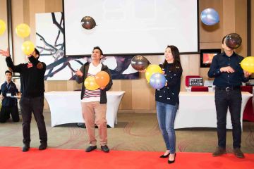 team having fun with colourful balloons win it in a minute competitive team building game